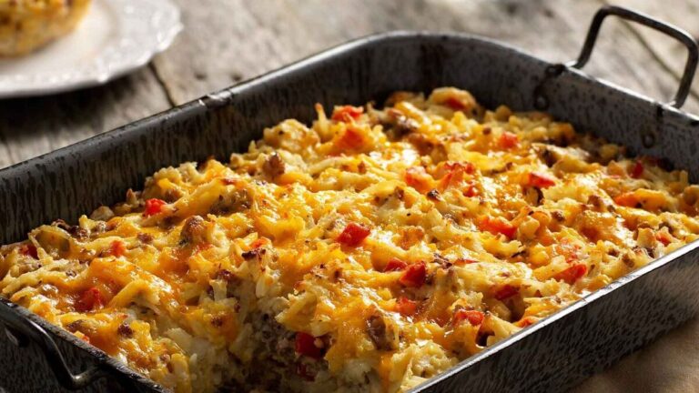 Delicious Amish Ham Casserole served in a baking dish, featuring layers of diced ham, egg noodles, cream of mushroom soup, and melted cheddar cheese, garnished with bread crumbs