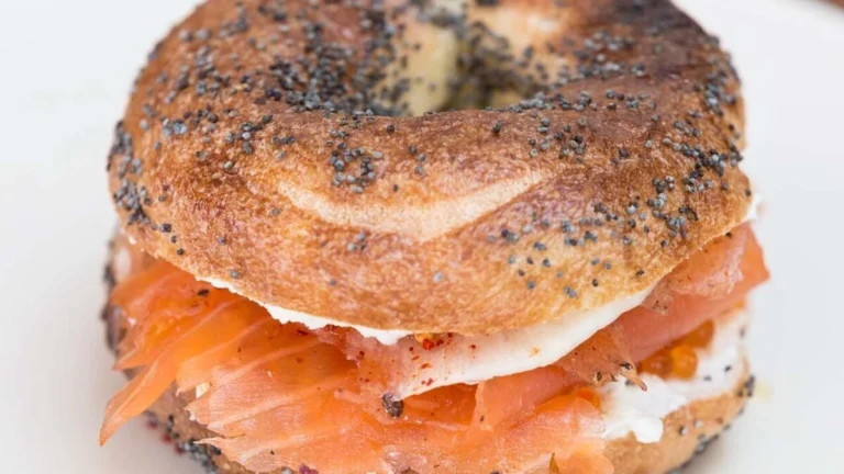 A delicious bagel topped with cream cheese, lox, red onions, and fresh tomatoes