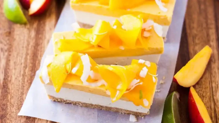 Decadent mango coconut cheesecake topped with fresh mango slices and shredded coconut