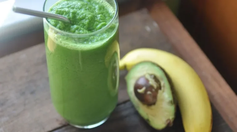 A vibrant Avocado, Blueberry, Banana, and Chia Smoothie in a glass, garnished with fresh blueberries and chia seeds.