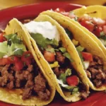 Delicious beef tacos filled with seasoned ground beef, topped with fresh lettuce, diced tomatoes, cheese, and salsa, served on warm corn tortillas.