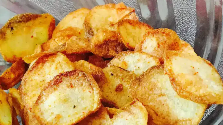 Homemade potato chips served in a bowl, garnished with herbs and spices.