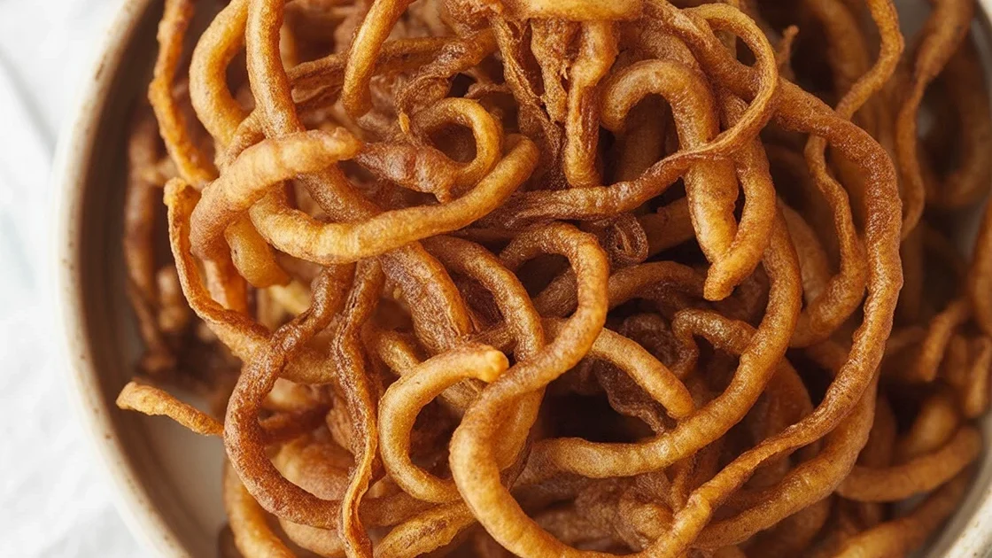 Crispy frizzled onions served on a burger with fresh toppings.