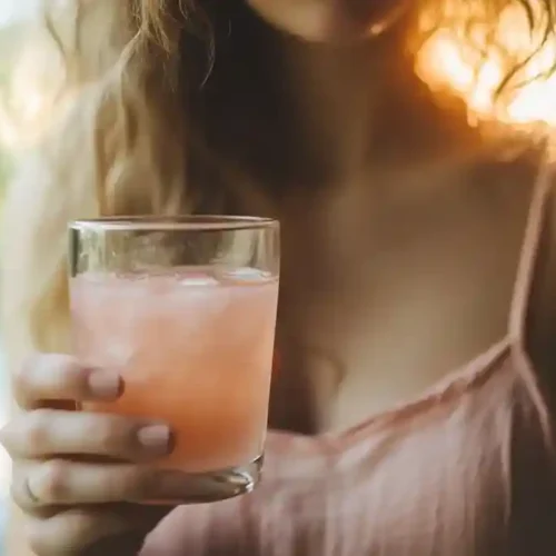 Pink salt trick recipe – woman drinking salt water at sunrise