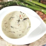 Delicious homemade truffle cream sauce drizzled over pasta with garnishes.